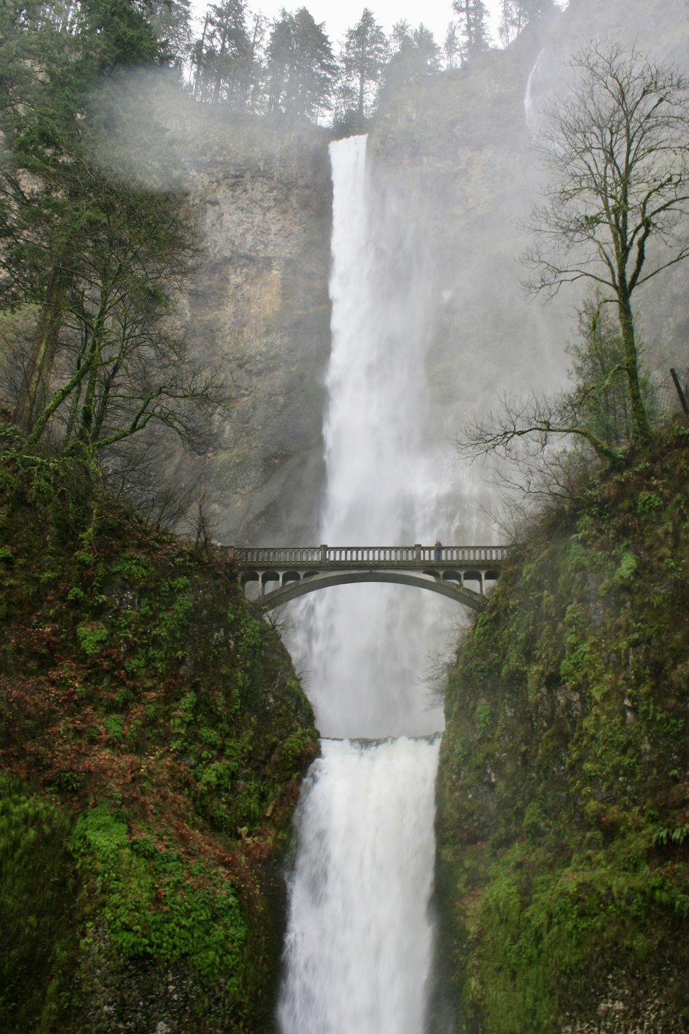 ein großer Wasserfall mit einer Brücke darüber