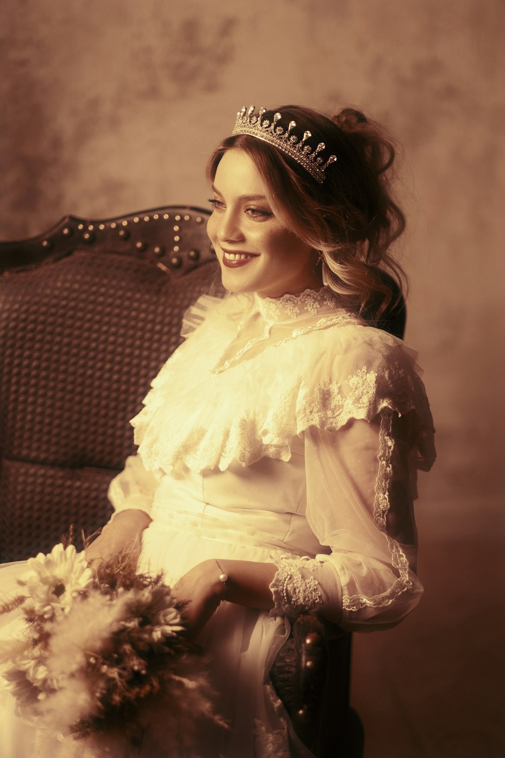 a woman wearing a tiara sitting in a chair