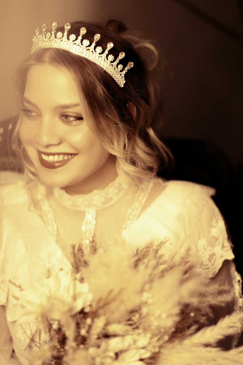 a woman wearing a tiara and holding a bouquet of flowers