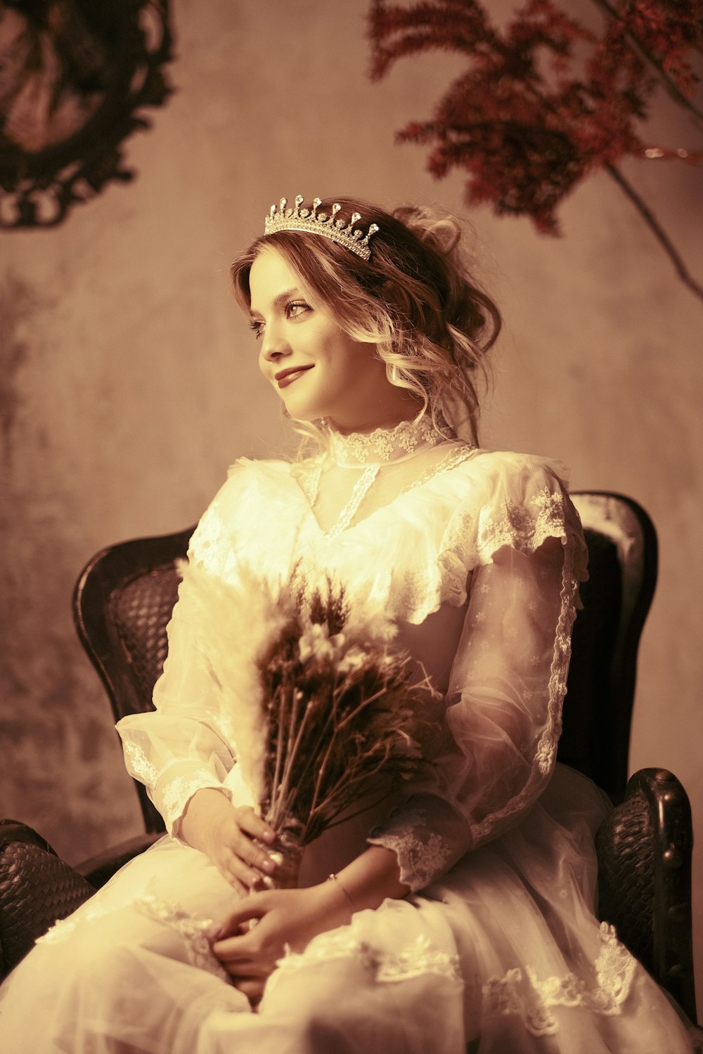 a woman sitting in a chair holding a bouquet of flowers