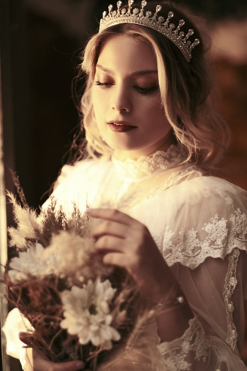 a woman wearing a tiara holding a bouquet of flowers