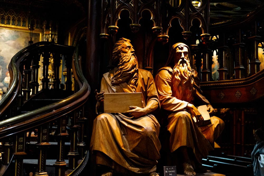 una estatua de dos hombres sentados uno al lado del otro