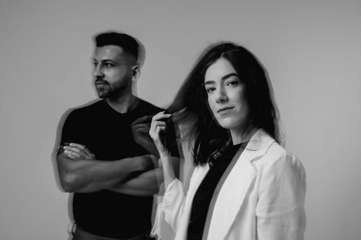 a man standing next to a woman brushing her hair