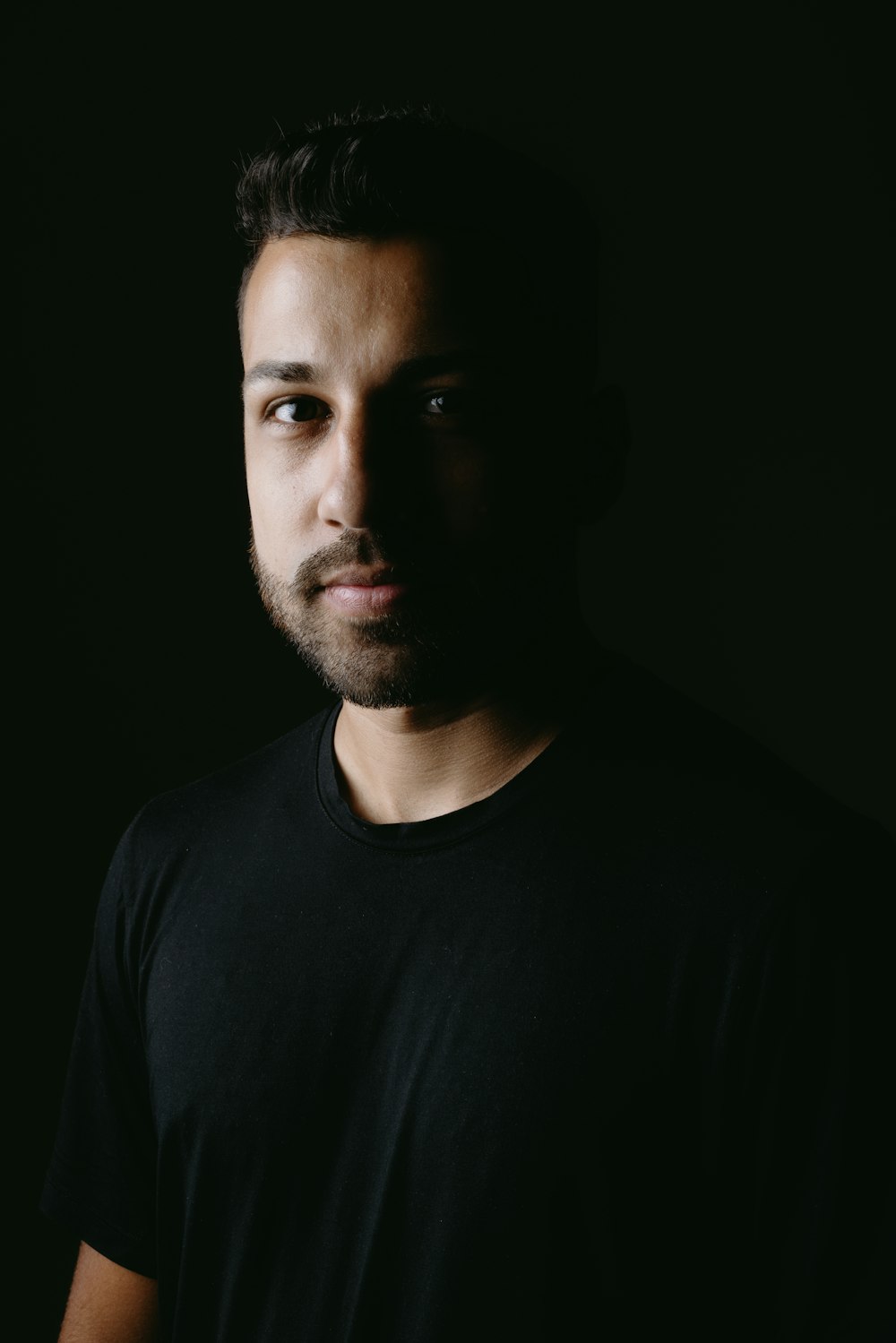 a man in a black shirt is posing for a picture