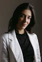 a woman wearing a white jacket and black shirt
