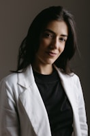 a woman wearing a white jacket and black shirt