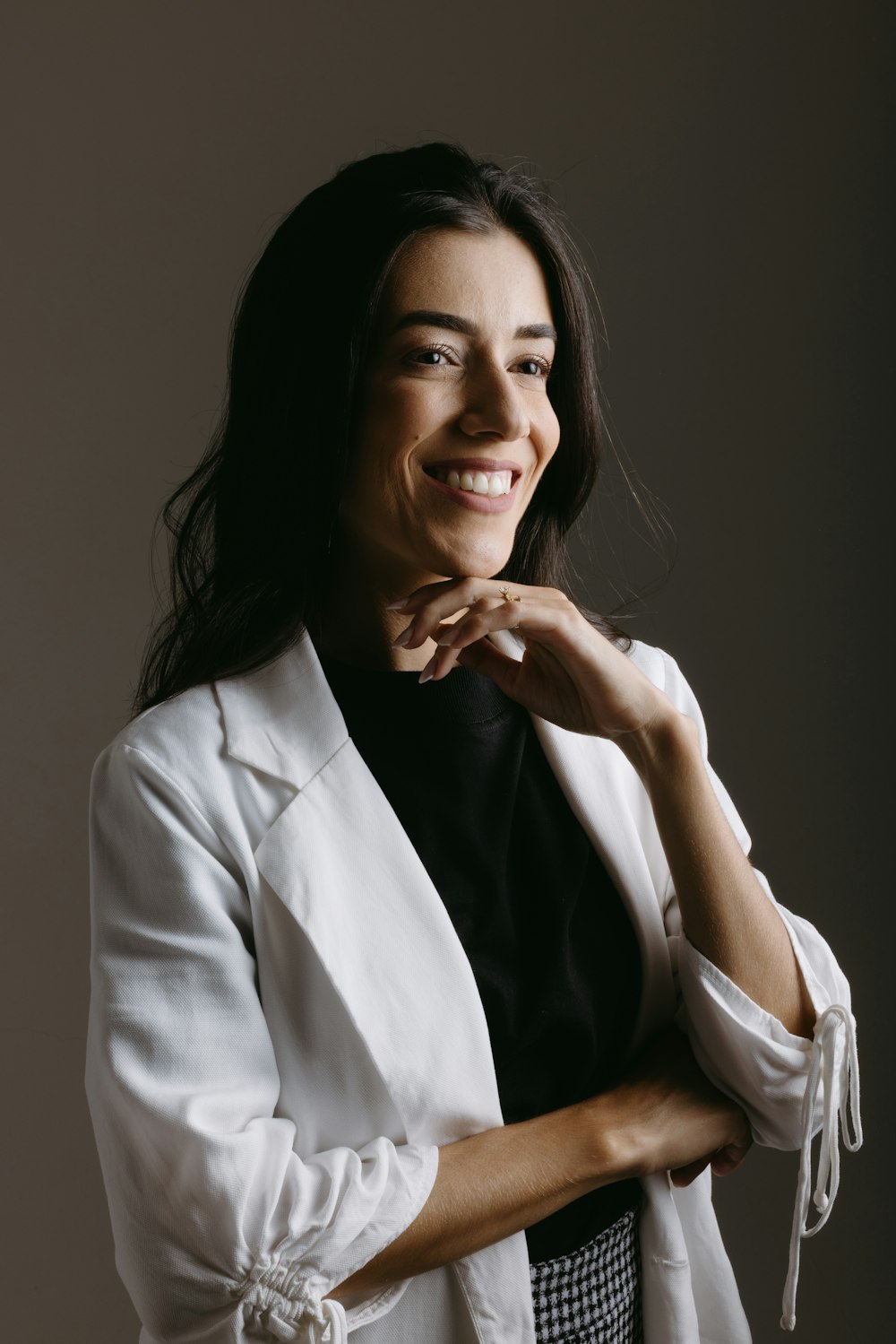 a woman in a white blazer smiling at the camera