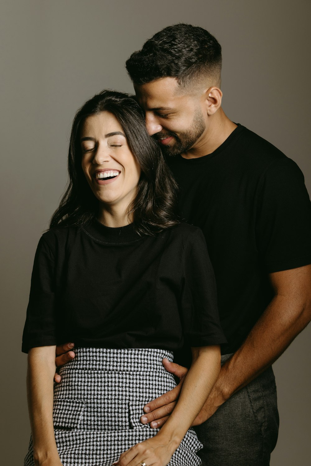 a man and a woman smile as they pose for a picture