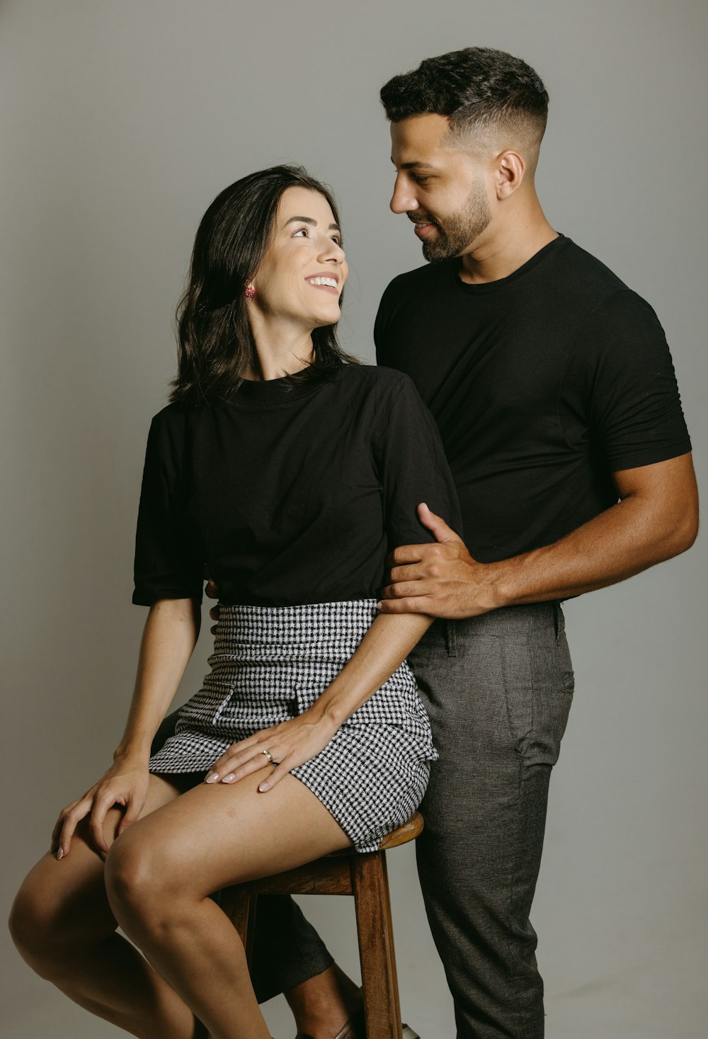 a man and a woman sitting on a stool