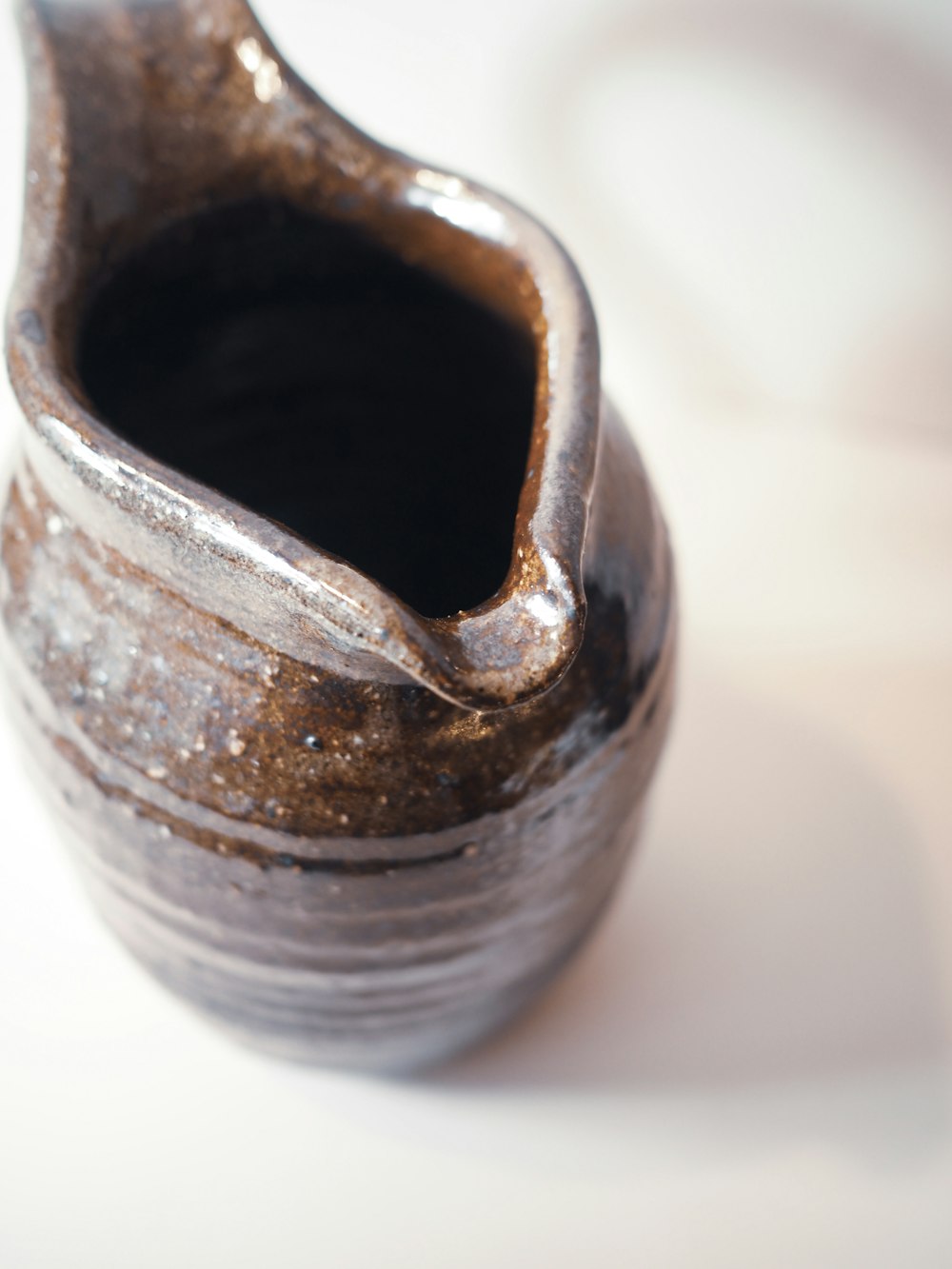 a silver vase sitting on top of a white table