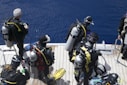 a group of scuba divers on a boat