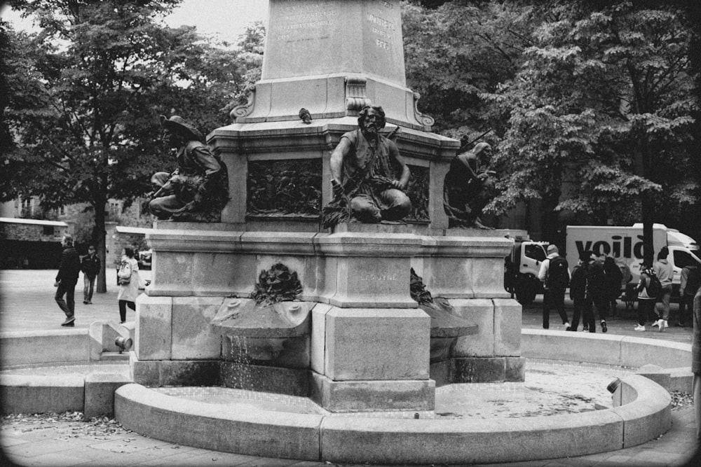 a black and white photo of a statue in a park