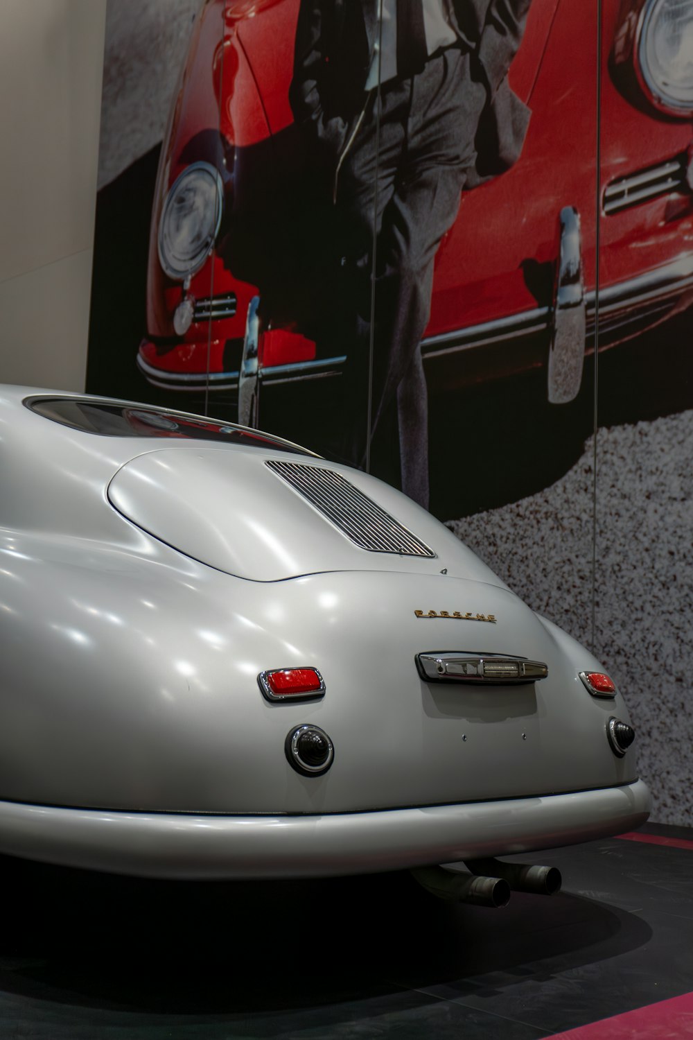 a silver sports car on display in a museum