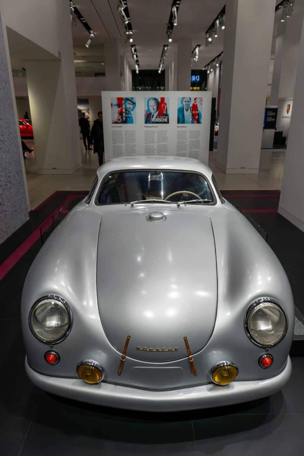 a silver sports car on display in a museum