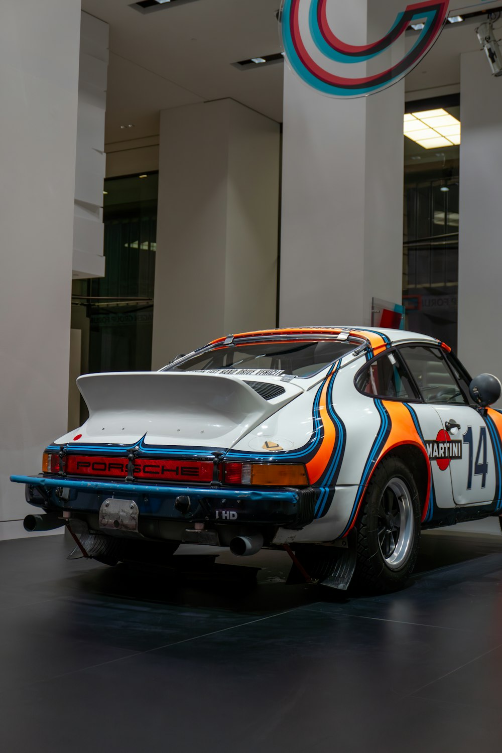 a white car with orange and blue stripes parked in a building