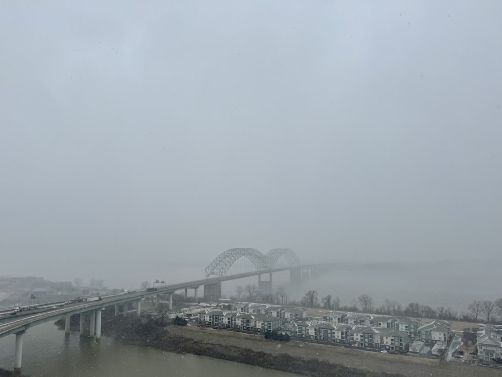 a view of a bridge over a river in the fog