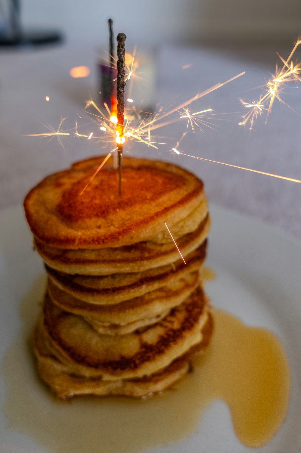 a stack of pancakes with a sparkler on top