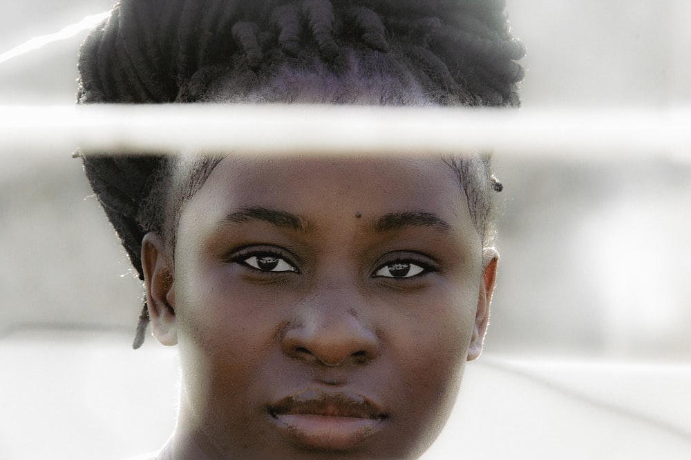 a close up of a person behind a fence