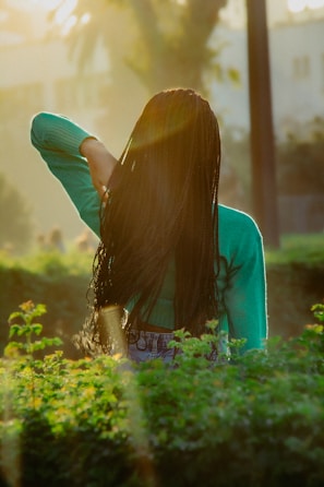 a woman with long hair standing in a field