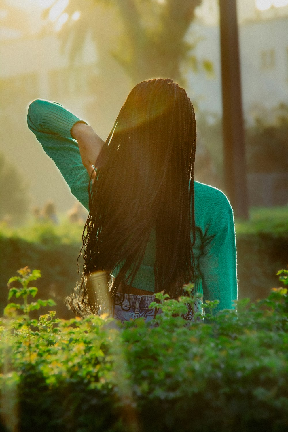 a woman with long hair standing in a field