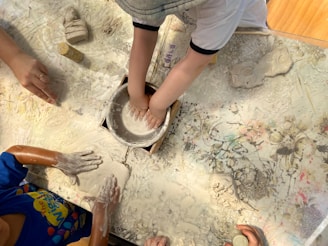 a group of children standing around a pottery bowl