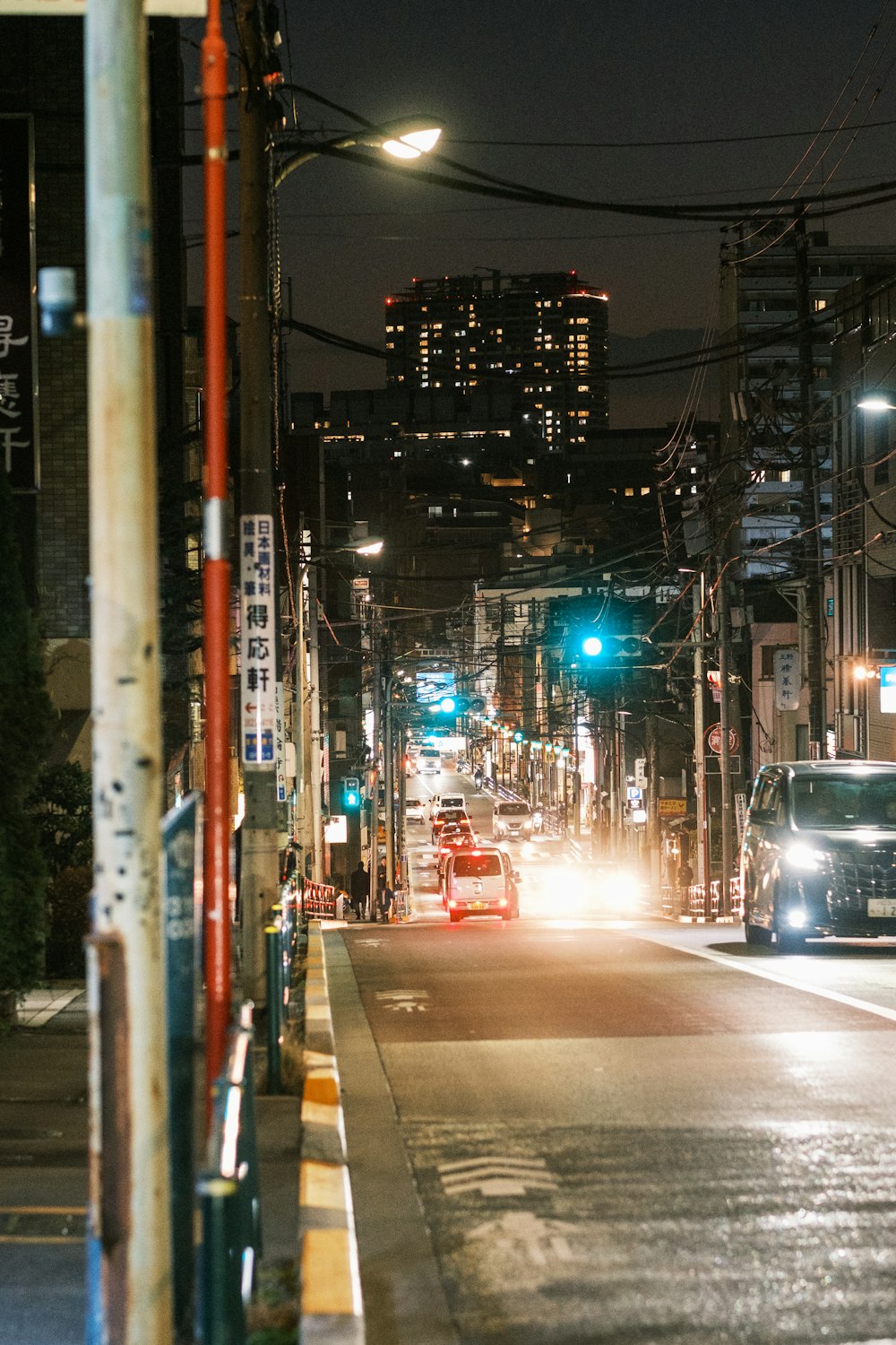 una calle de la ciudad por la noche con coches que circulan por ella