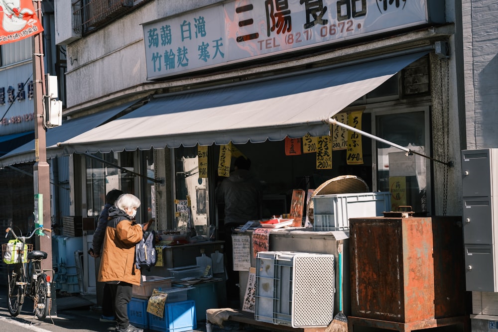 Un hombre parado frente a una tienda en una calle de la ciudad