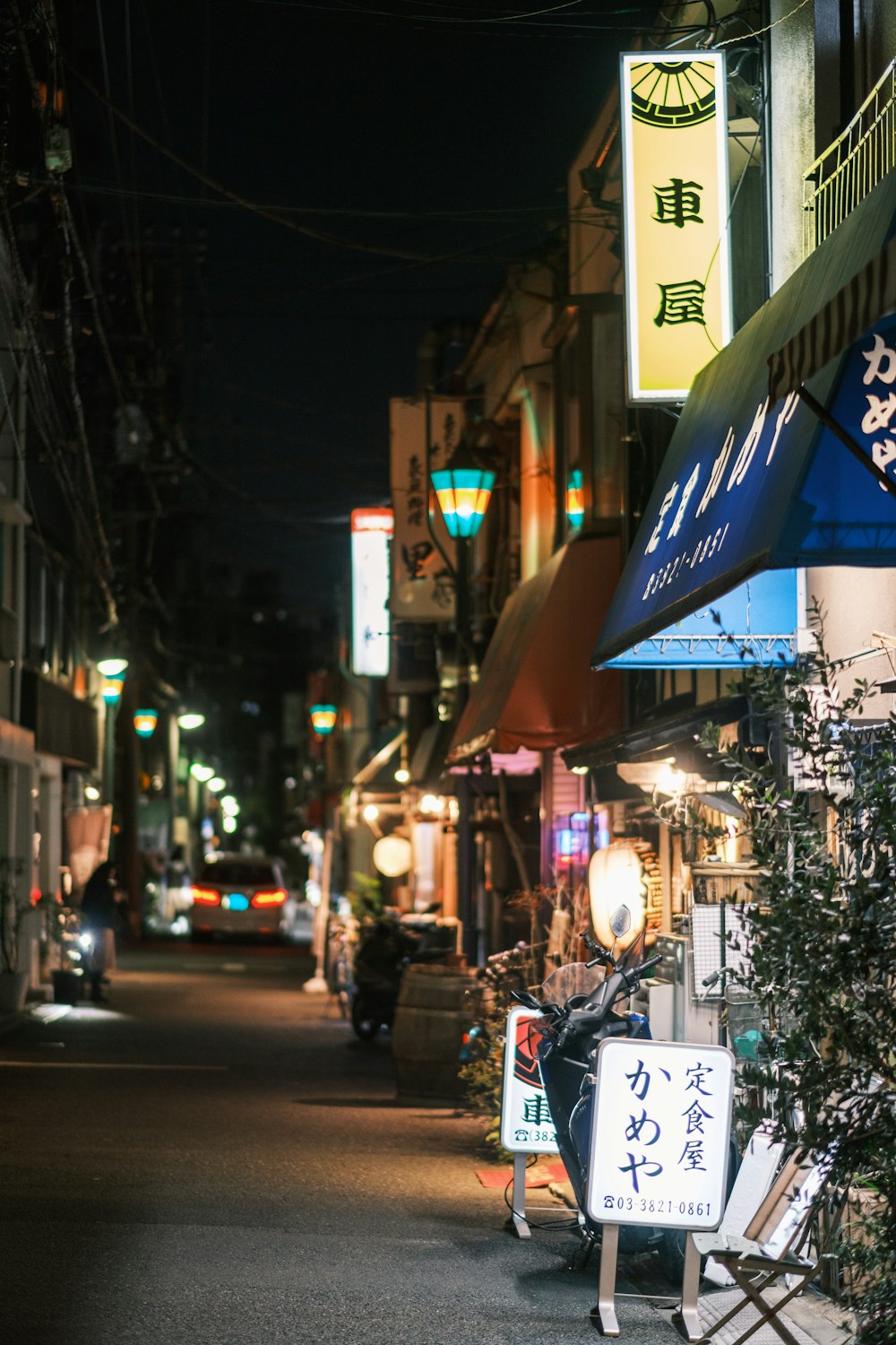 Una calle de la ciudad por la noche con letreros y luces