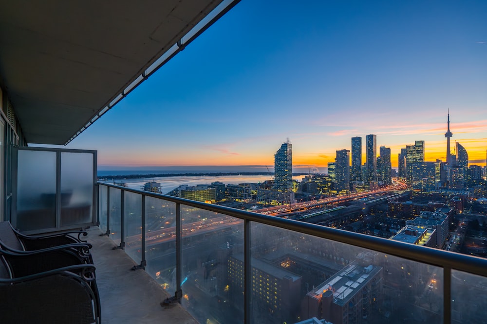 a balcony with a view of a city at sunset