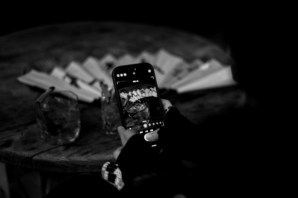 a person taking a picture of a table with books