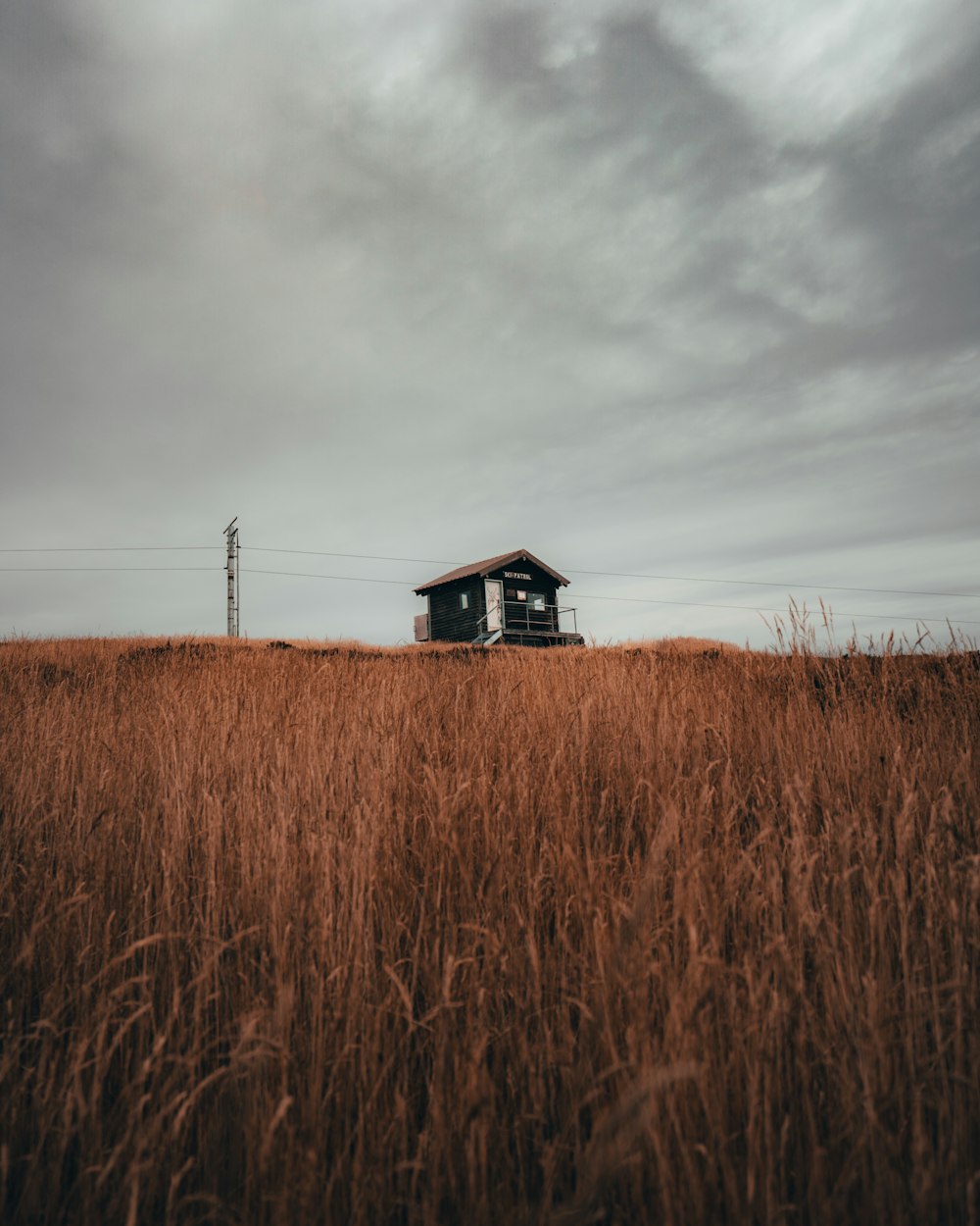 a small house sitting on top of a dry grass field