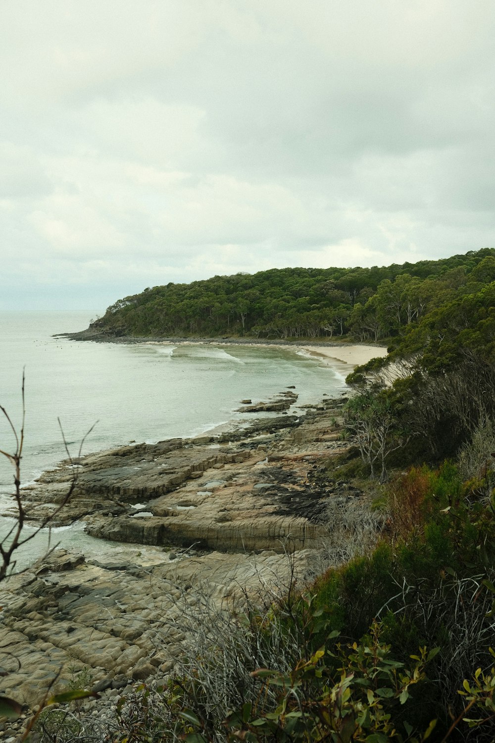 a view of a rocky beach with a body of water in the distance