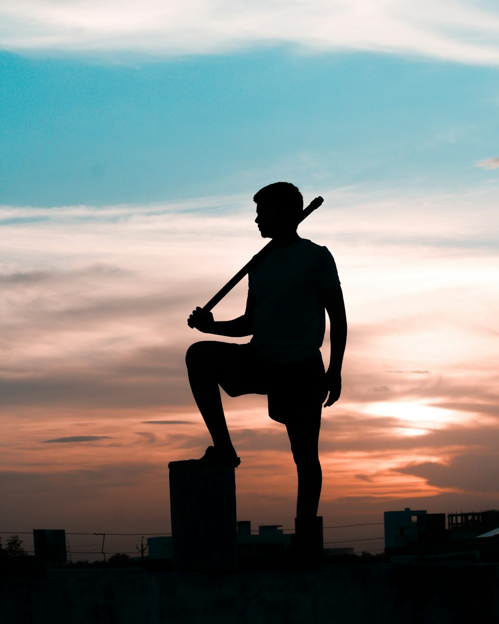 a silhouette of a man holding a baseball bat