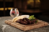 a wooden cutting board topped with meat and veggies