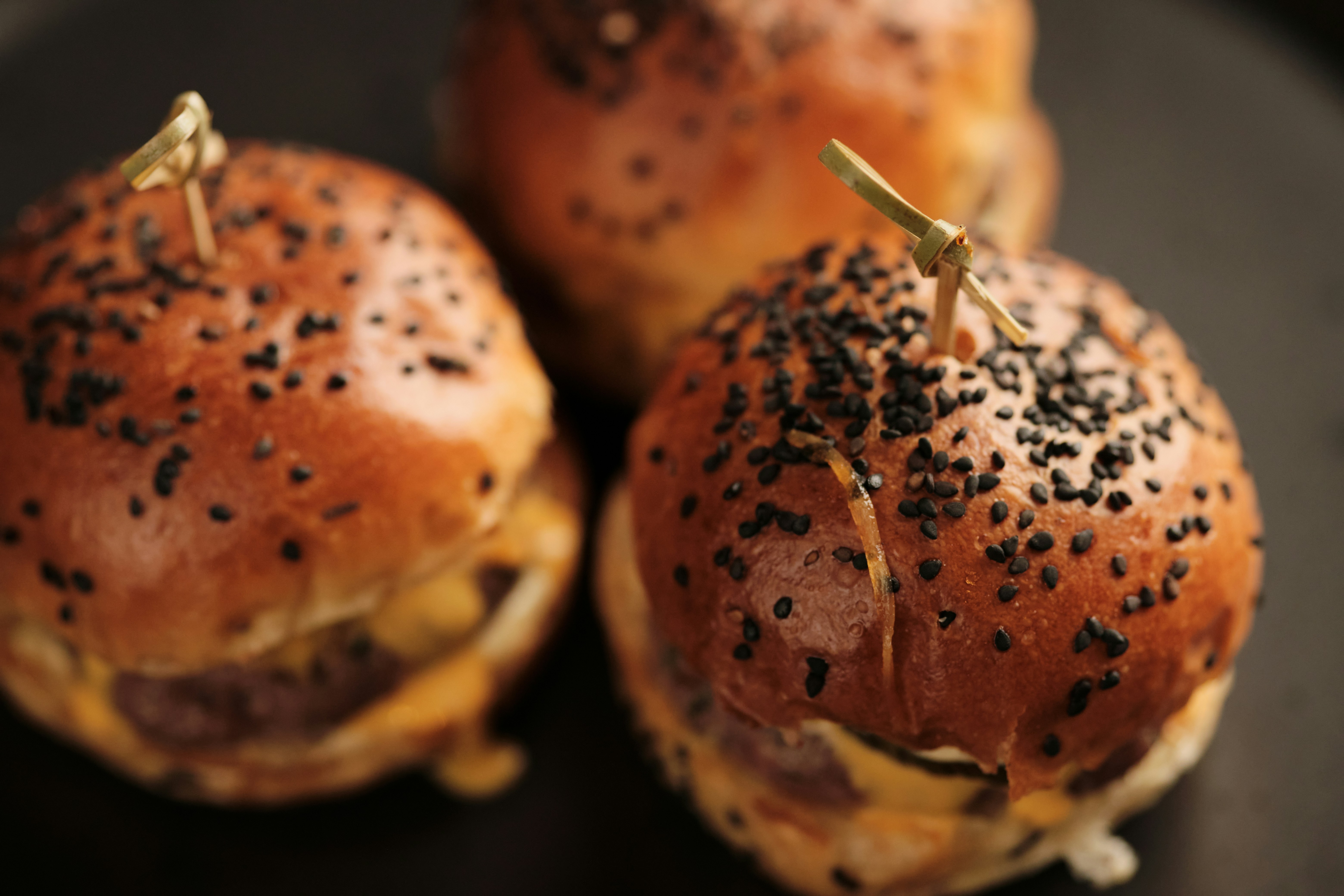 a close up of three hamburgers on a plate
