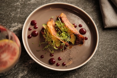 a plate of food on a table next to a glass of wine
