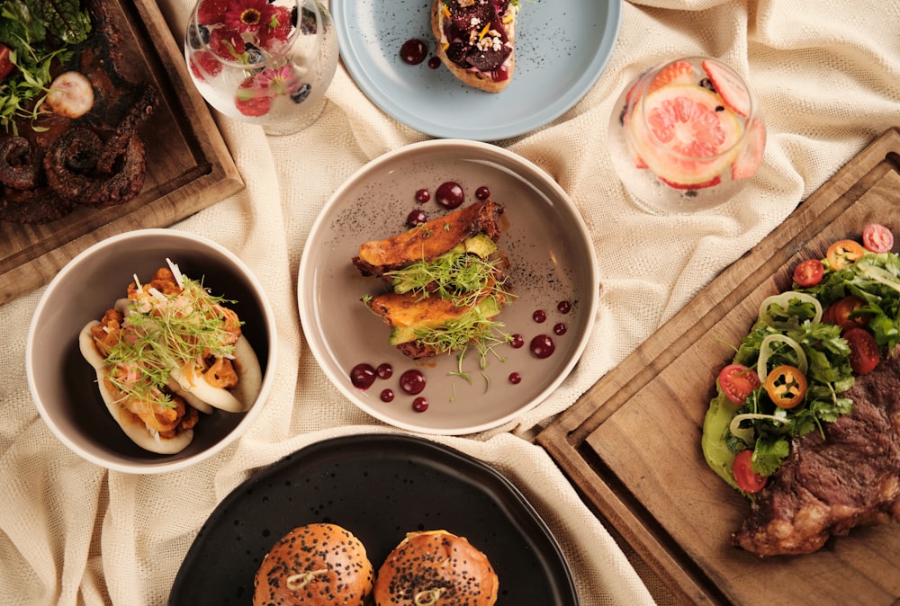 a table topped with plates and bowls filled with food