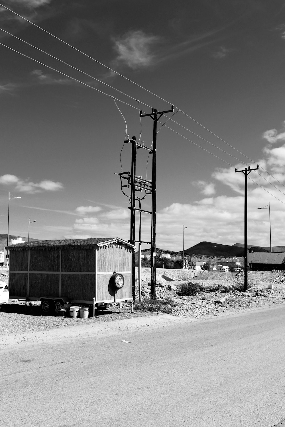 ein Schwarz-Weiß-Foto von Stromleitungen und Telefonmasten