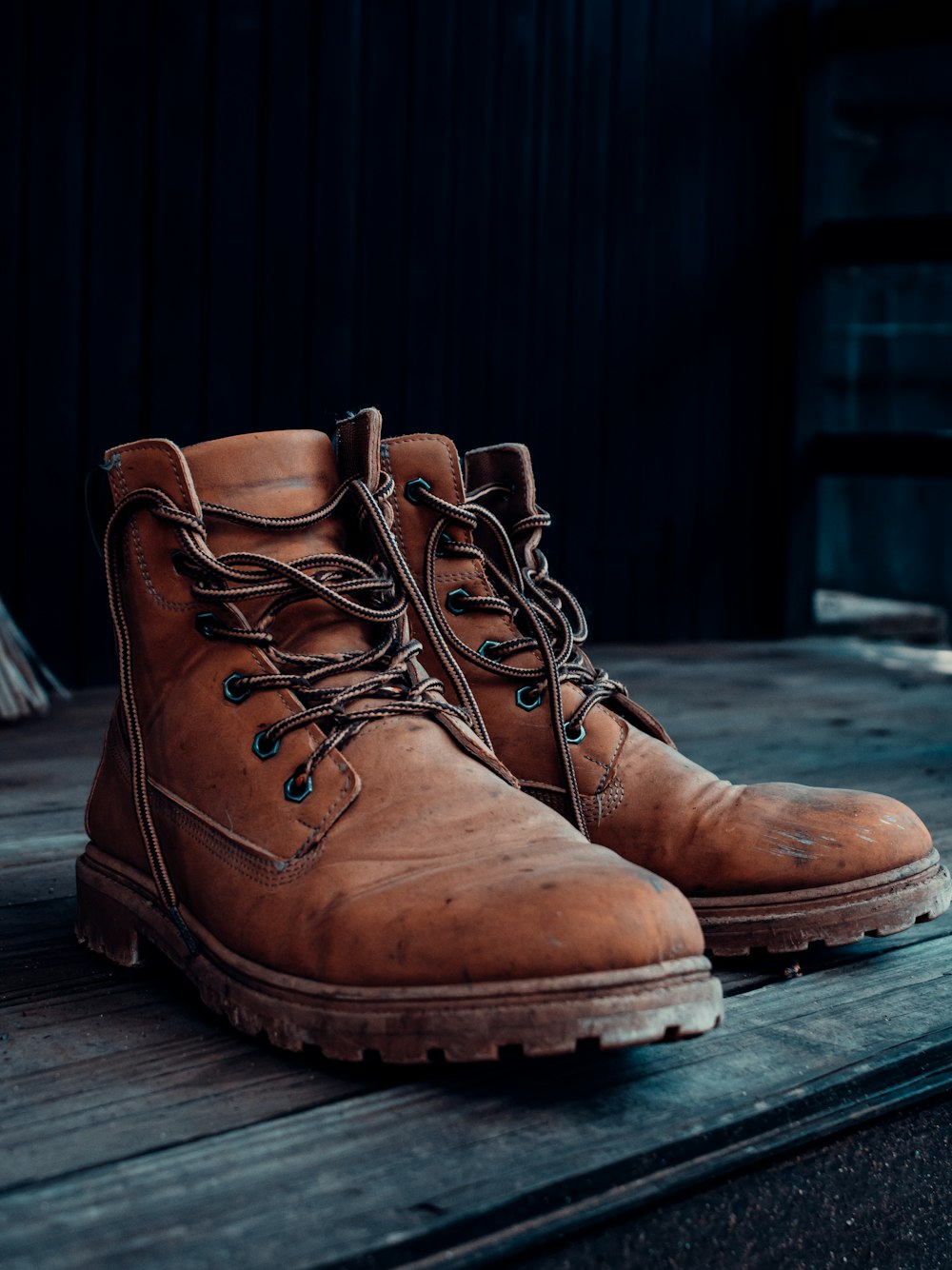 a pair of brown boots sitting on top of a wooden floor