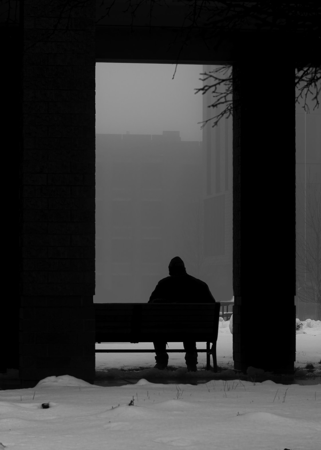 a person sitting on a bench in the snow