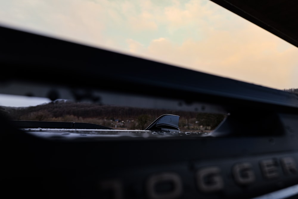 a close up of a car mirror with a sky in the background