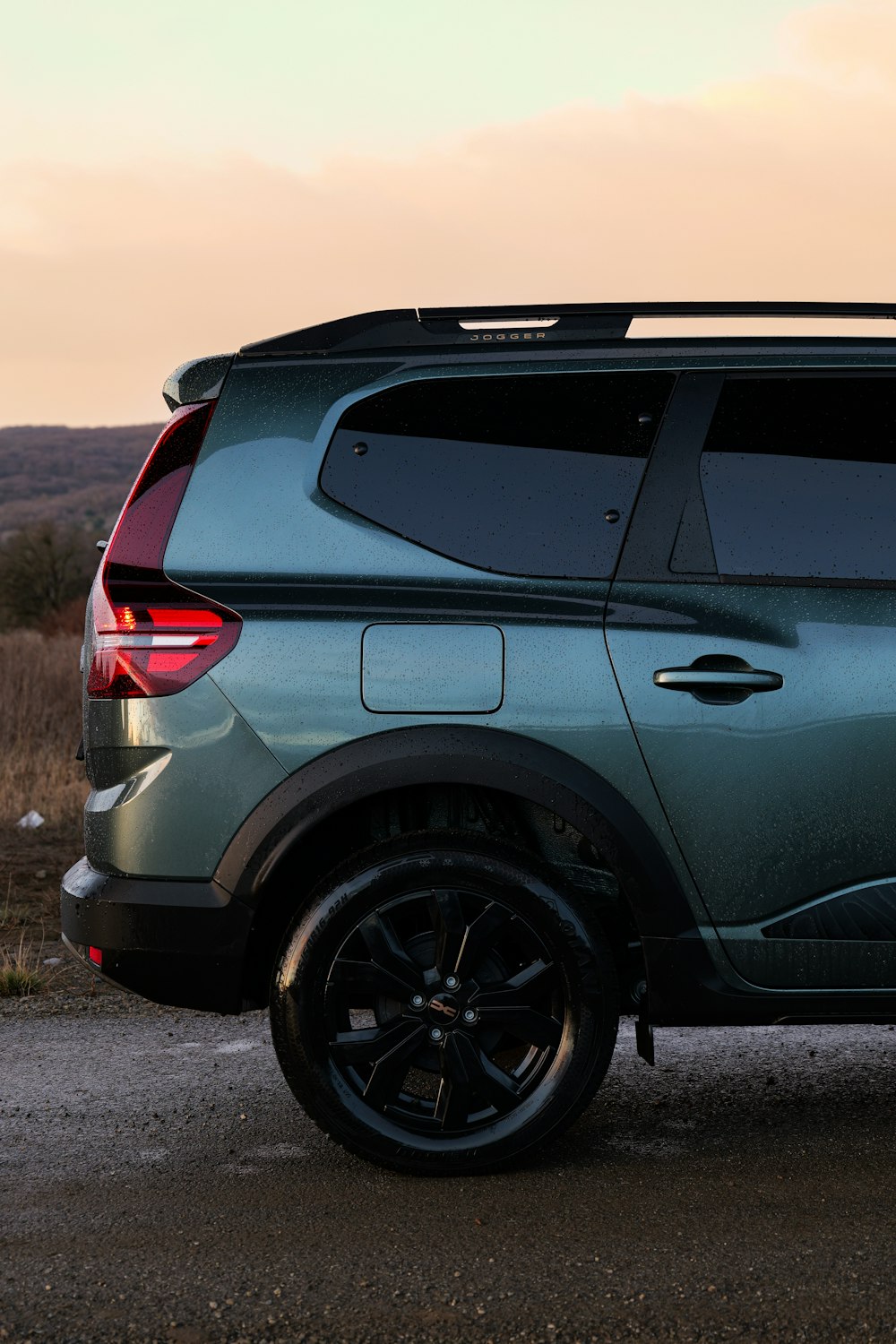 a green suv parked on the side of a road