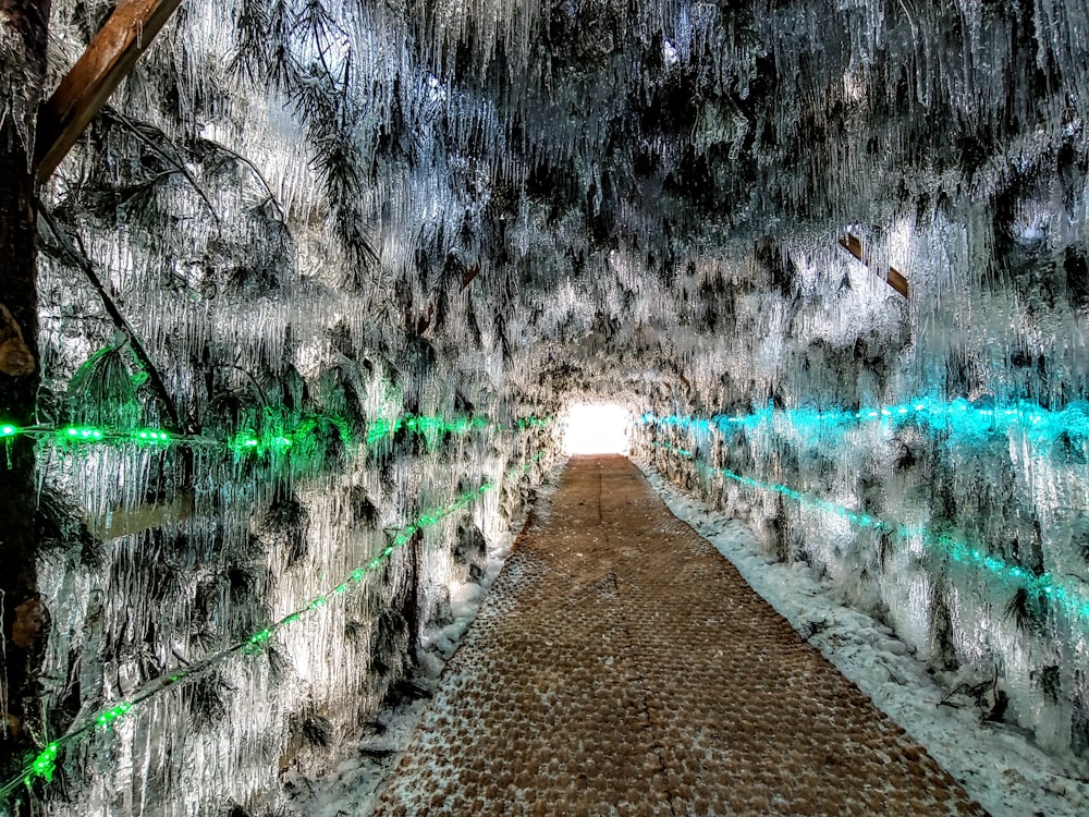 a tunnel of ice and icicles with a light at the end