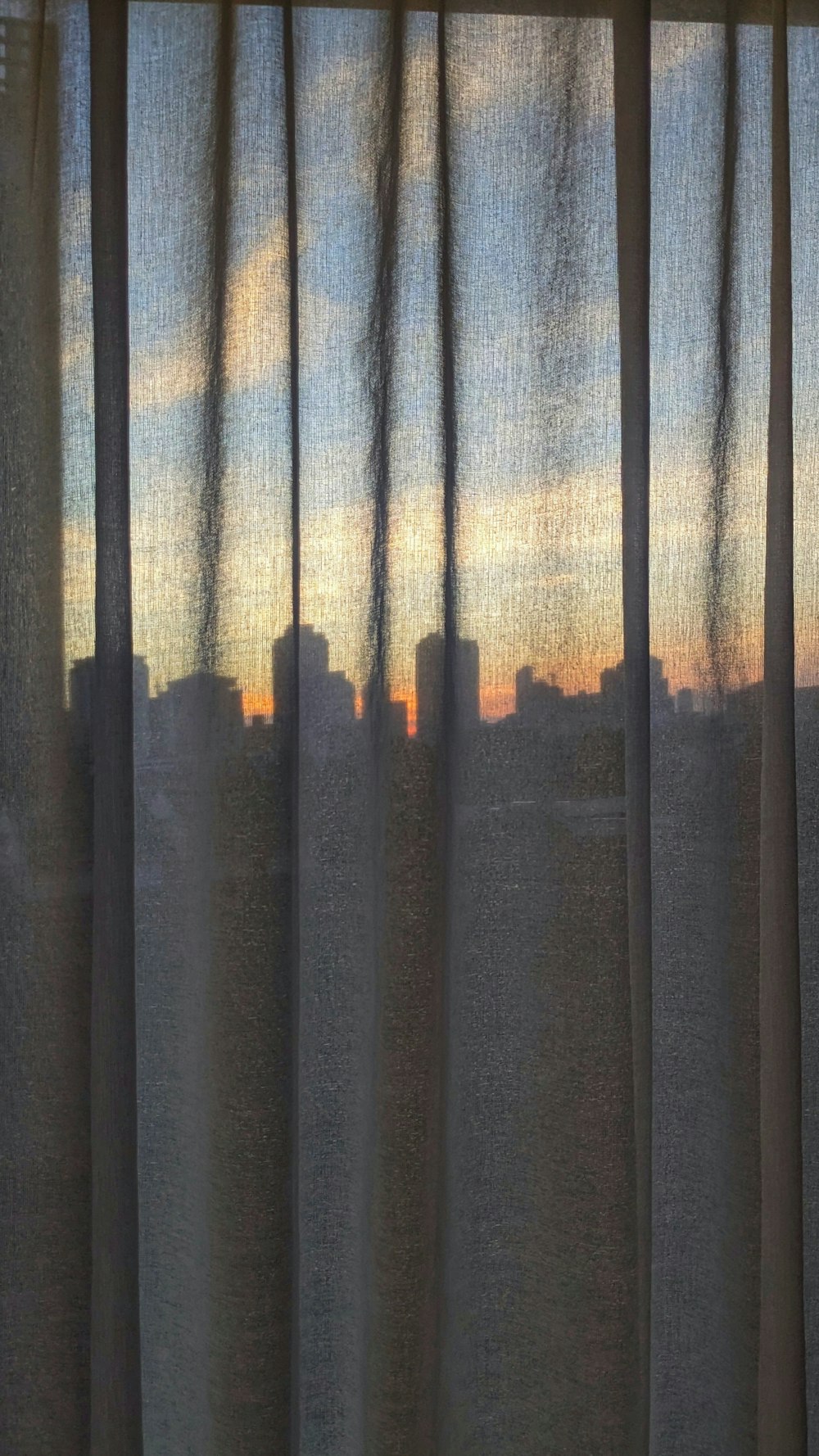 a view of a city from a window at sunset