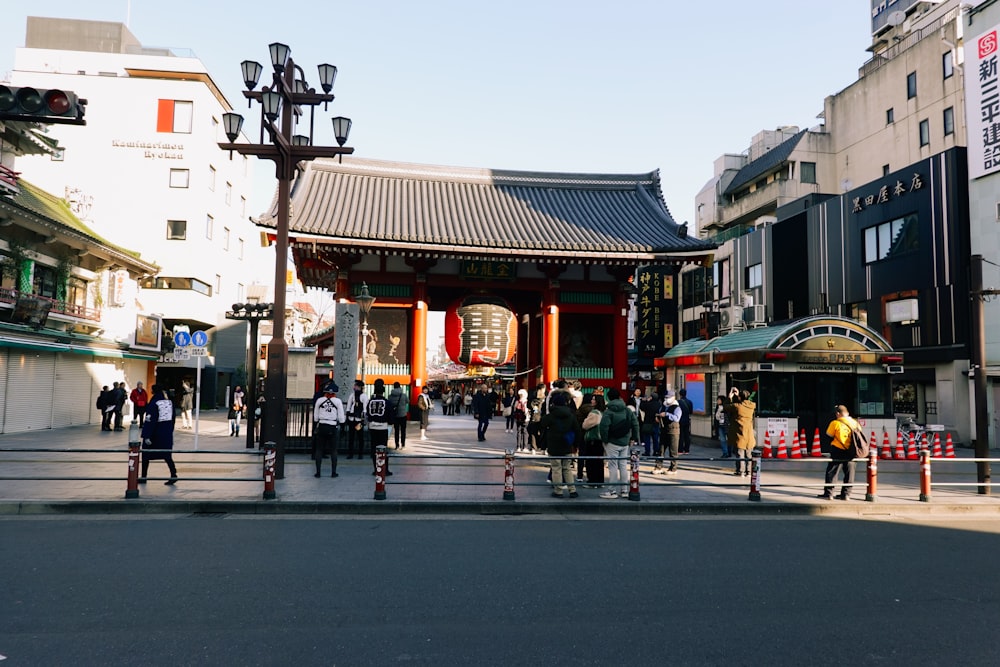 a group of people walking down a street next to tall buildings