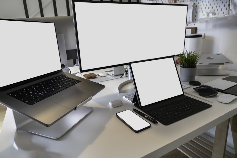 a desk with two laptops and a phone on it