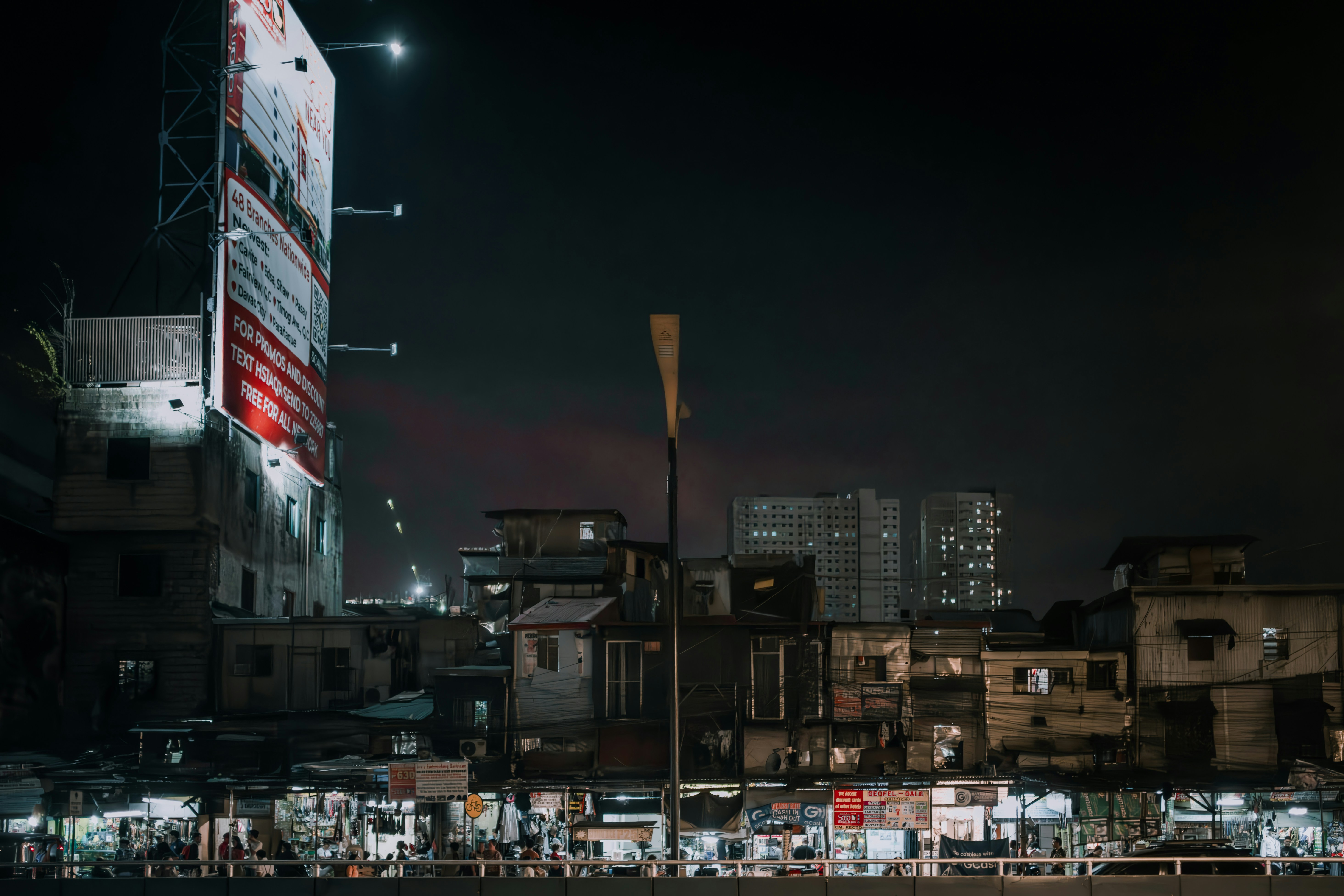 a city street at night with a large billboard in the background