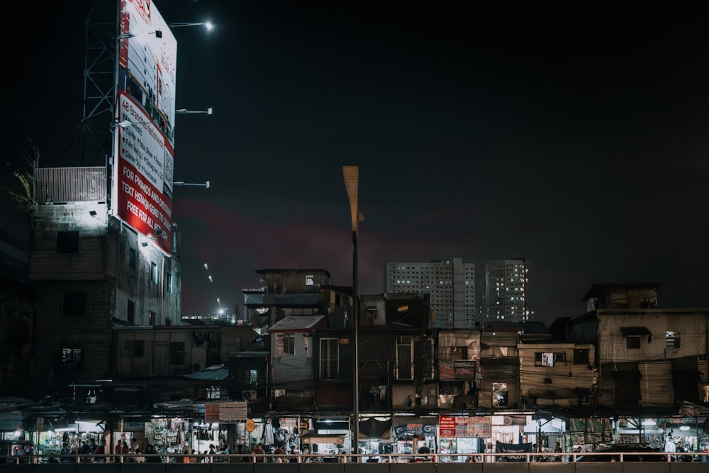 a city street at night with a large billboard in the background