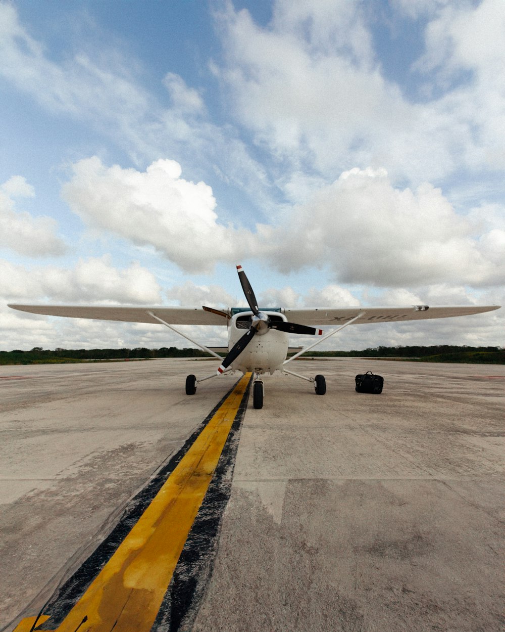 a small propeller plane sitting on top of an airport tarmac