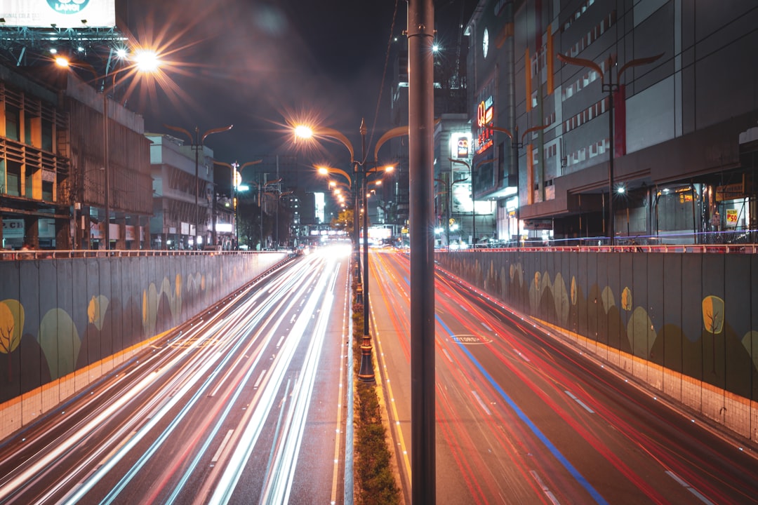 a city street filled with lots of traffic at night, Recto perspective.